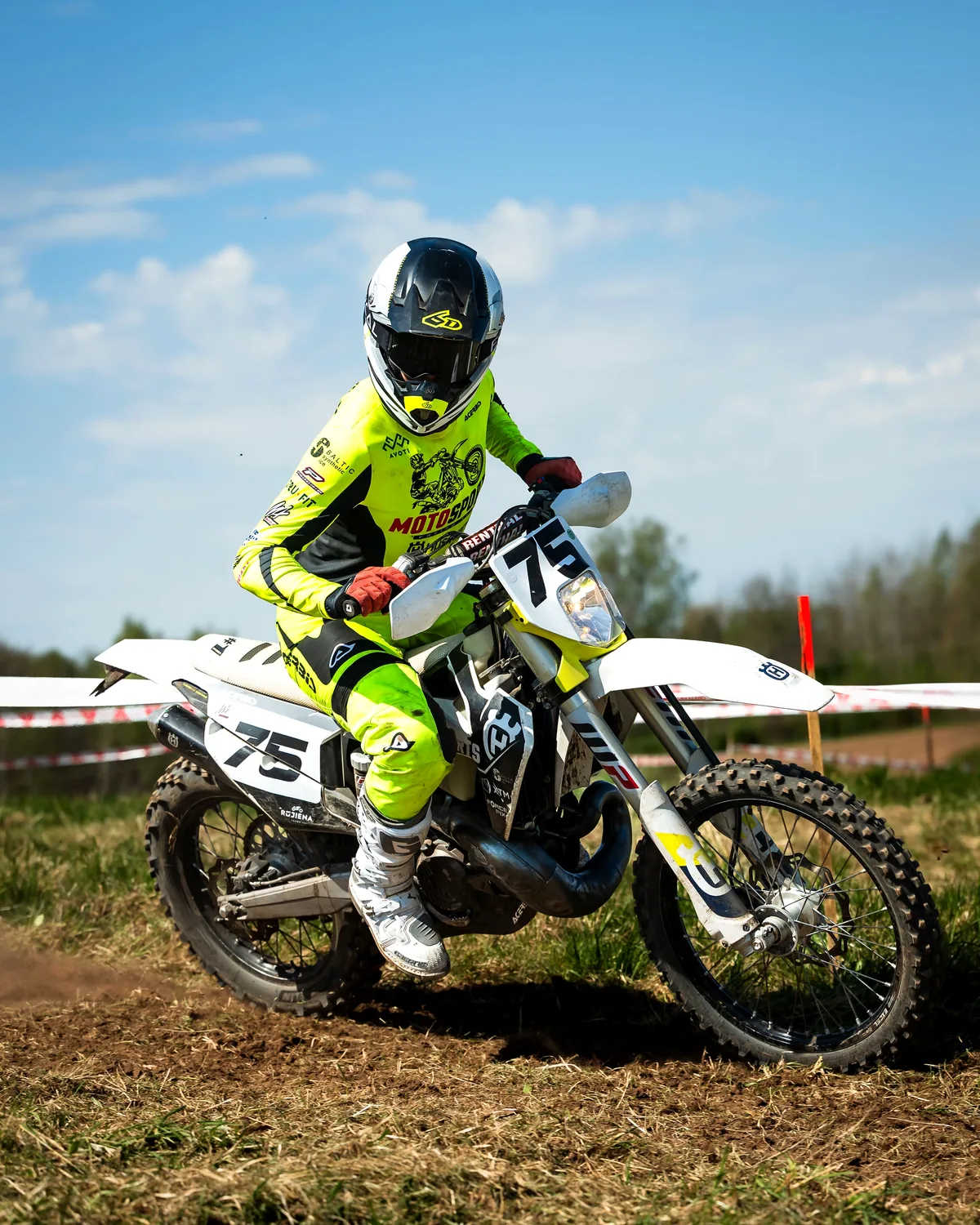 Gustavs zaļā motokrosa ekipējumā uz motocikla